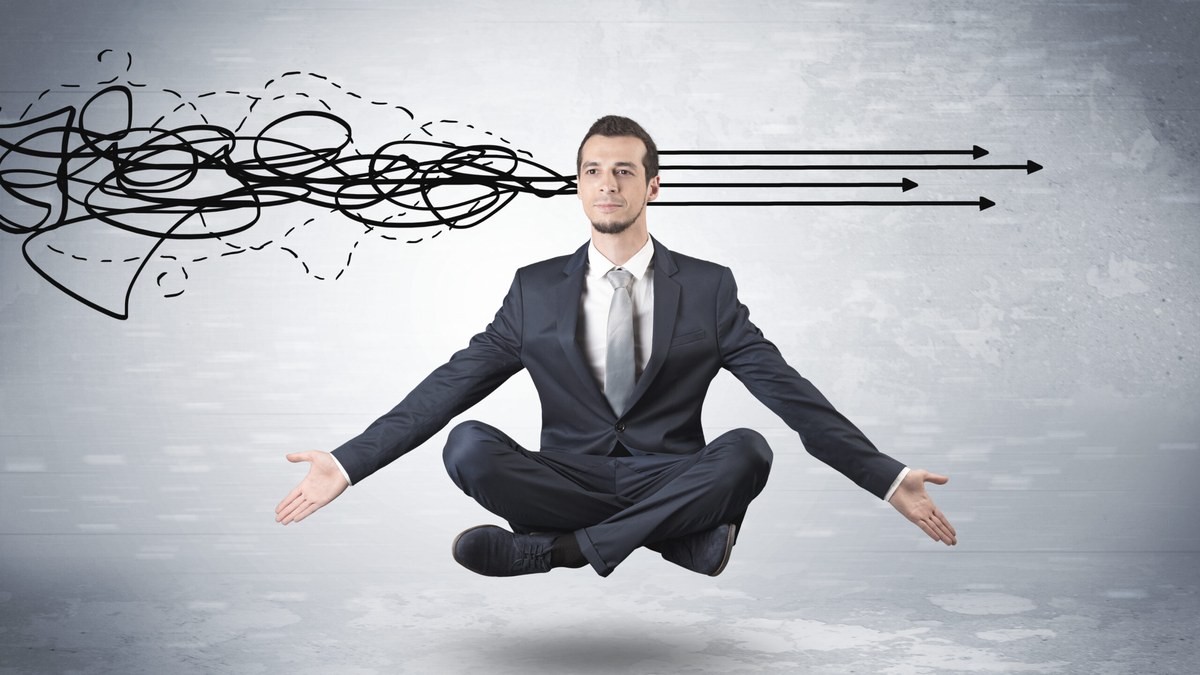 Businessman in a suit sits cross‑legged mid‑air with open arms; chaotic scribbles on the left give way to straight arrows on the right.