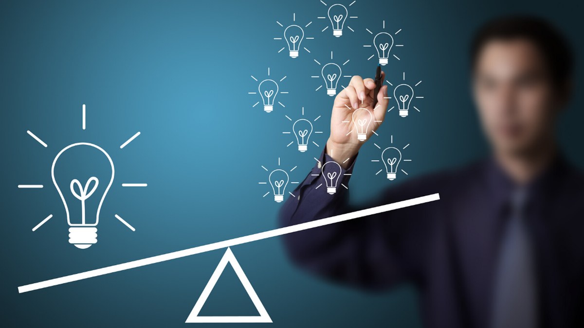 Person in a suit balances a large light bulb on one side of a seesaw with many small light bulbs on the other, symbolizing ideas and balance